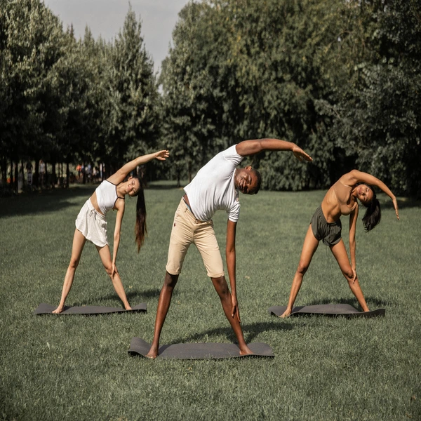3 people in a park doing yoga